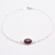 Sterling Silver Bezel-set Garnet Bracelet shown on flat white surface with focus on the Garnet