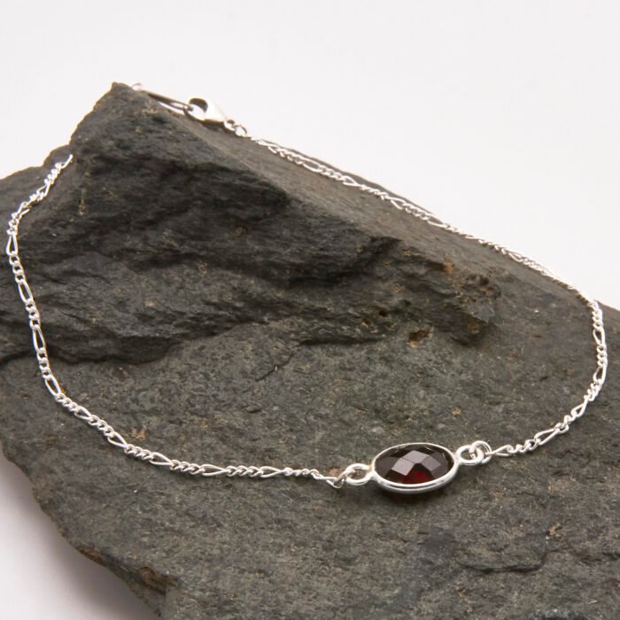 Sterling Silver Bezel-set Garnet Bracelet shown on dark grey stone