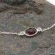 Sterling Silver Bezel-set Garnet Bracelet close up of Garnet on dark grey stone