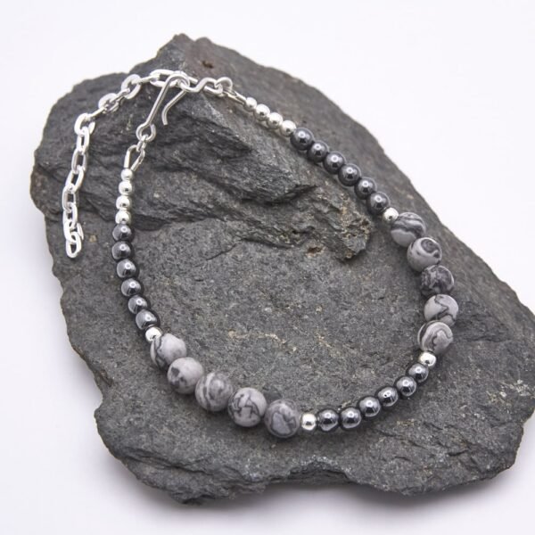 Grey Banded Agate and Hematite Sterling Silver Bracelet shown on grey stone
