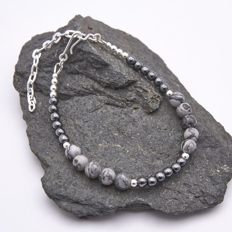 Grey Banded Agate and Hematite Sterling Silver Bracelet shown on grey stone
