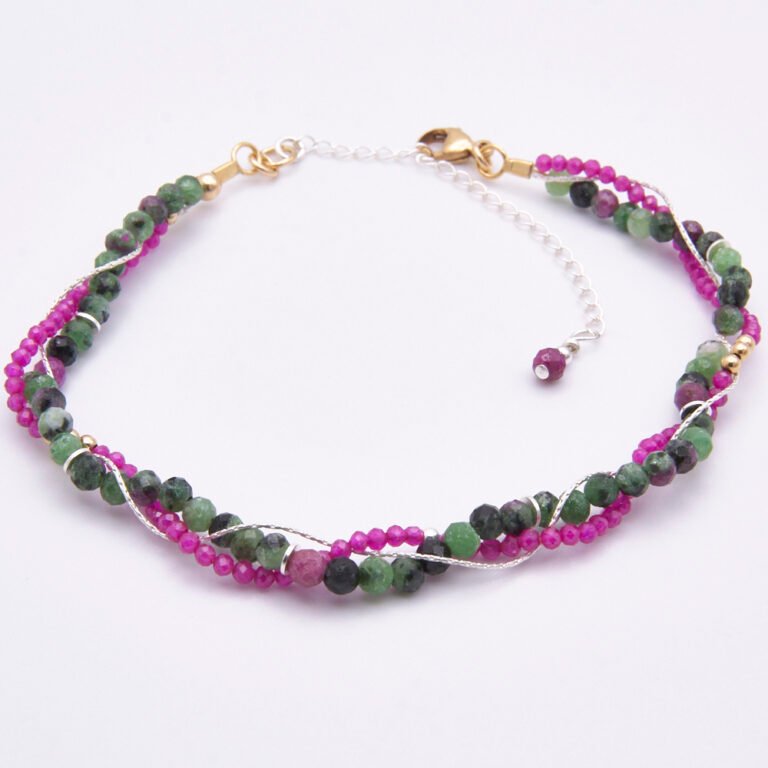 A three strand bracelet of Ruby, Ruby Zoisite & sterling silver fine chain woven into a loose braid, accented with gold and silver beads and spacers and finished with a gold lobster clasp and silver extender chain