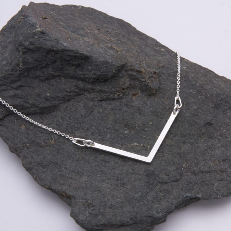 Sterling Silver Wide Angle Bar Necklace shown laid flat on dark grey stone