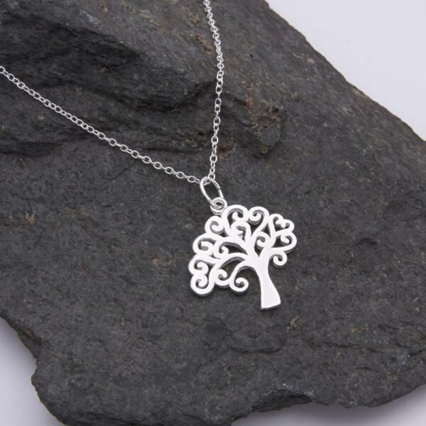 Tree Charm Sterling Silver Necklace shown close up on grey stone