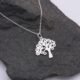 Tree Charm Sterling Silver Necklace shown close up on grey stone