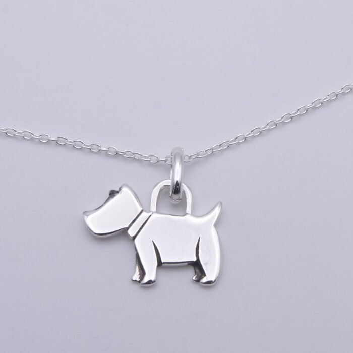 Dog Charm Sterling Silver Necklace shown close up on flat white surface