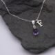 Amethyst Teardrop Pendant Necklace with added Initial Charm close up on dark grey stone