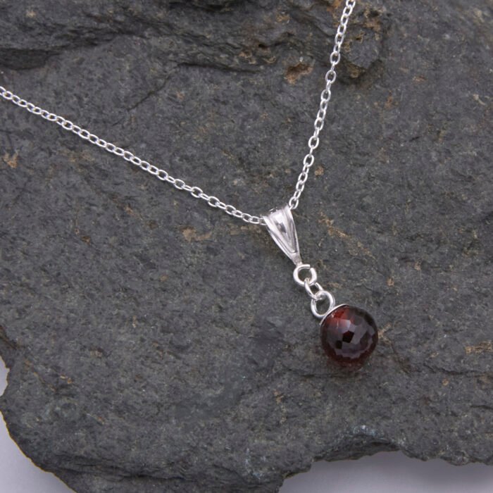 Garnet Ball and Sterling Silver Pendant Necklace close-up on stone