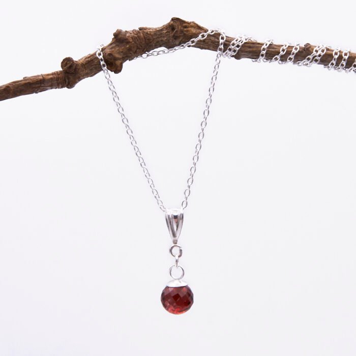 Garnet Ball and Sterling Silver Pendant Necklace hanging from twig