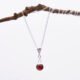 Garnet Ball and Sterling Silver Pendant Necklace hanging from twig