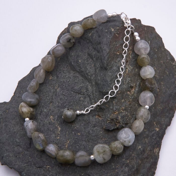 Labradorite Smooth Chip Bead Sterling Silver Bracelet with extender chain with wire-wrapped bead decoration shown on dark grey stone