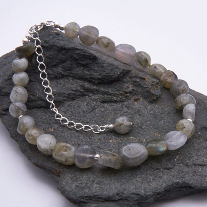 Labradorite Smooth Chip Bead Sterling Silver Bracelet with extender chain with wire-wrapped bead decoration, shown on dark grey stone