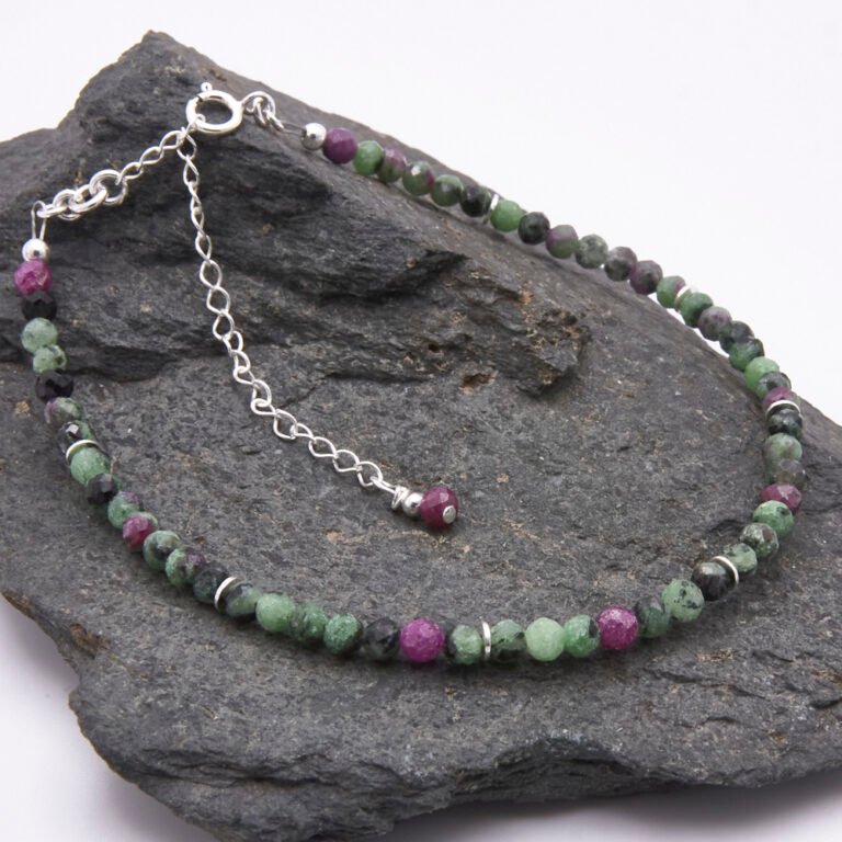 Ruby Zoisite Sterling Silver Bracelet with faceted round Ruby Zoisite beads interspersed with sterling silver flat spacers and finished with a sterling silver spring ring clasp and extender chain with ruby bead trim