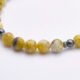 Yellow Turquoise and Hematite Sterling Silver Bracelet with Magnetic Clasp close up of part of bead strand on flat white surface