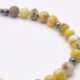 Yellow Turquoise and Hematite Sterling Silver Bracelet with Magnetic Clasp close up of part of bead strand on flat white surface
