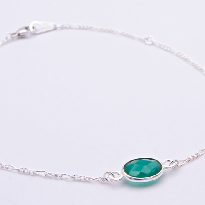 Sterling Silver Bezel-Set Green Onyx Bracelet close up of Green Onyx on flat white surface