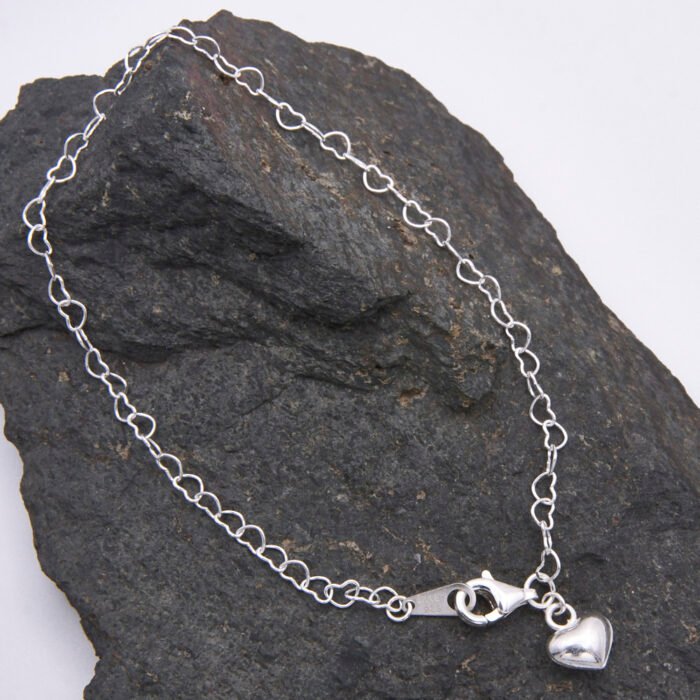 Sterling Silver Heart Link Chain Bracelet with Puffy Heart Charm on dark grey rock Sterling Silver Heart Link Chain Bracelet with Puffy Heart Charm on dark grey rock