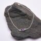 Sterling Silver Bezel-set Amethyst Bracelet with Figaro Chain shown on dark grey stone