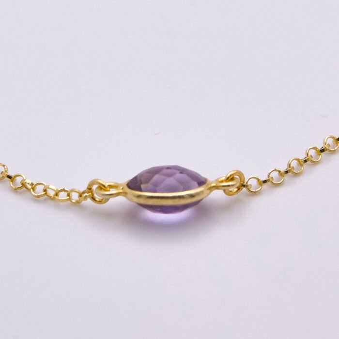 Amethyst 24k Gold Plated Sterling Silver Bracelet on flat white surface showing side on close up of bezel-set amethyst