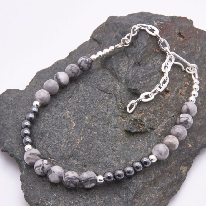 Grey Banded Agate and Hematite Sterling Silver Bracelet with extender chain shown on dark grey stone