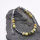Yellow Turquoise and Hematite Bracelet with Lobster Clasp and Extender Chain shown on grey stone