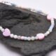 Mother of Pearl Heart Trio Bracelet close up of beads and hearts shown on dark grey stone