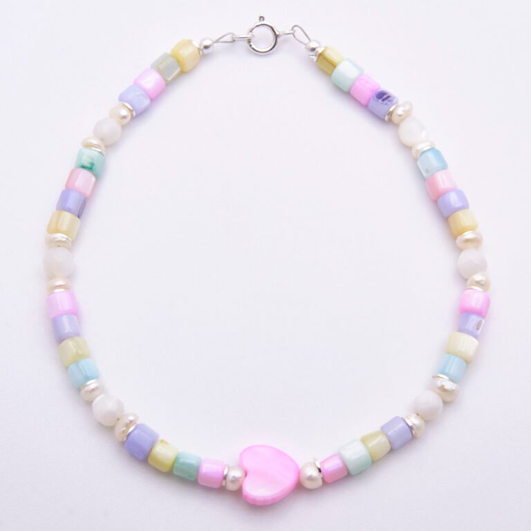 Mother of Pearl and Freshwater Pearl Single Heart Bracelet Mother of Pearl and Freshwater Pearl Heart Bracelet shown from above on flat white surface