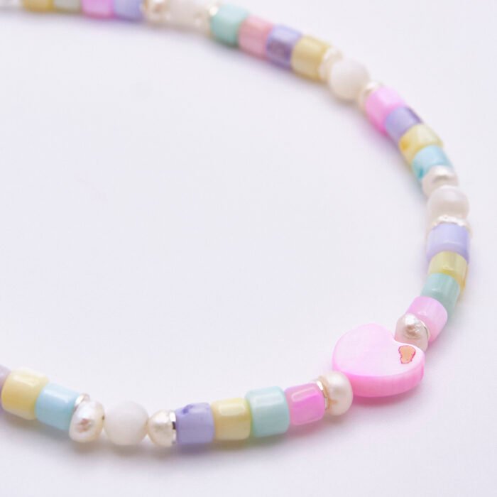 Mother of Pearl and Freshwater Pearl Single Heart Bracelet Mother of Pearl and Freshwater Pearl Single Heart Bracelet close up of beads on flat white surface