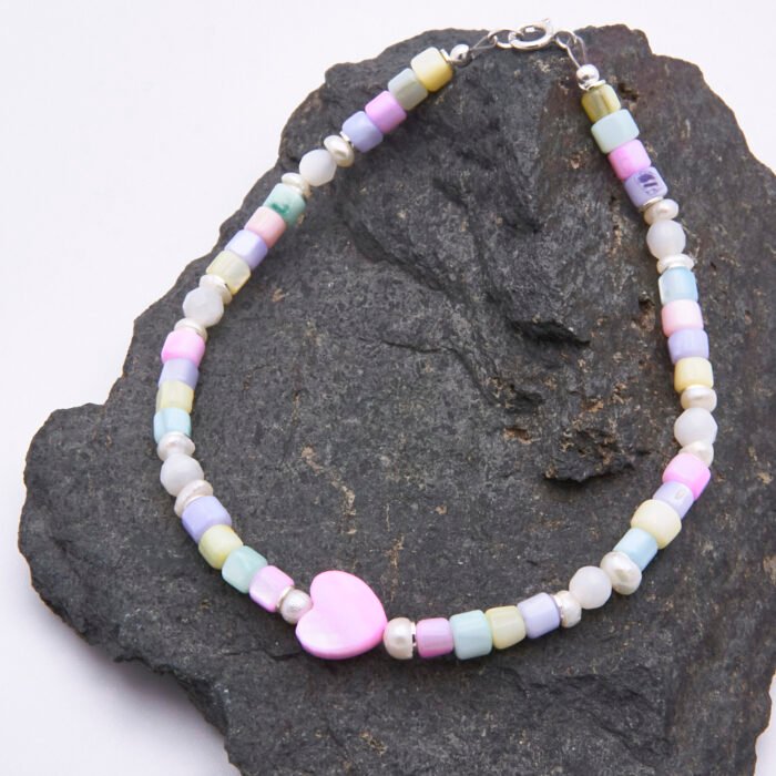 Mother of Pearl and Freshwater Pearl Single Heart Bracelet Mother of Pearl and Freshwater Pearl Single Heart Bracelet shown on dark grey stone