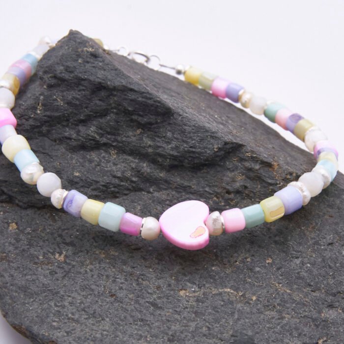Mother of Pearl and Freshwater Pearl Single Heart Bracelet Mother of Pearl and Freshwater Pearl Single Heart Bracelet close up of heart on dark grey stone