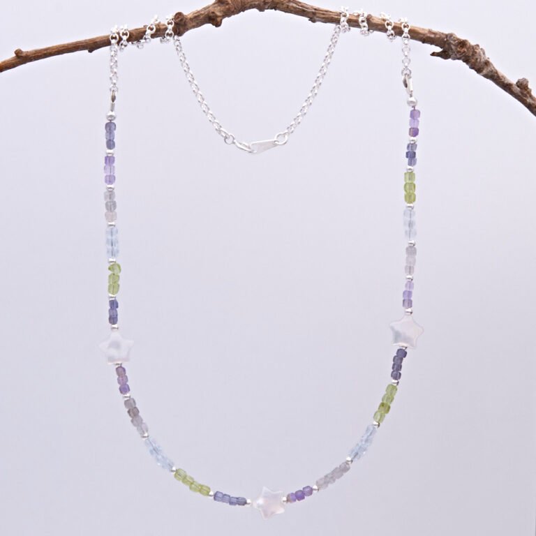 Mixed Gemstone and Mother of Pearl Star Sterling Silver Necklace comprising a selection of faceted gemstone cube beads all measuring around 2.5mm, interspersed with 2mm sterling silver rounds, with three lustrous chunky Mother of Pearl stars equally spaced between the gemstones. The remainder is made up of sterling silver rolo chain finished with a spring ring clasp stamped 925. Necklace is shown hanging from twig.