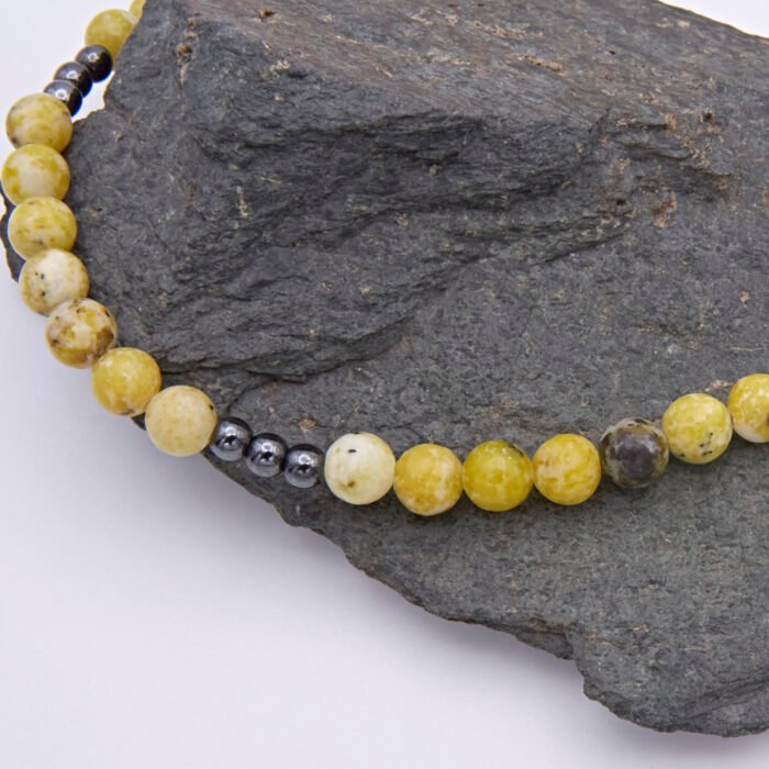 Yellow Turquoise and Hematite Bead Necklace close up of beads on dark grey stone