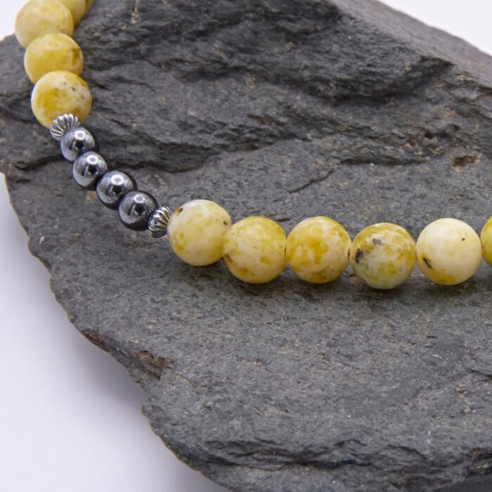 Yellow Turquoise and Hematite Necklace close up of beaded sections on dark grey rock