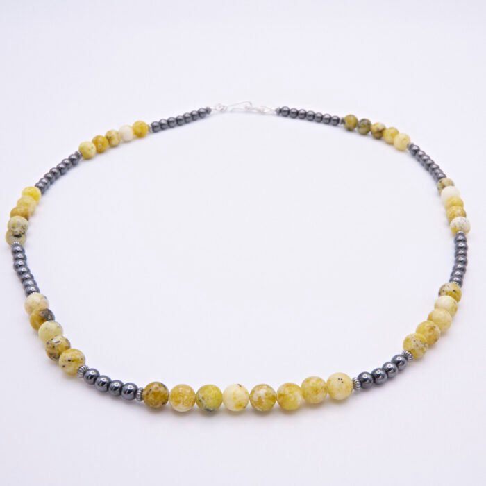 Yellow Turquoise and Hematite Necklace viewed flat from front to back on plain white surface