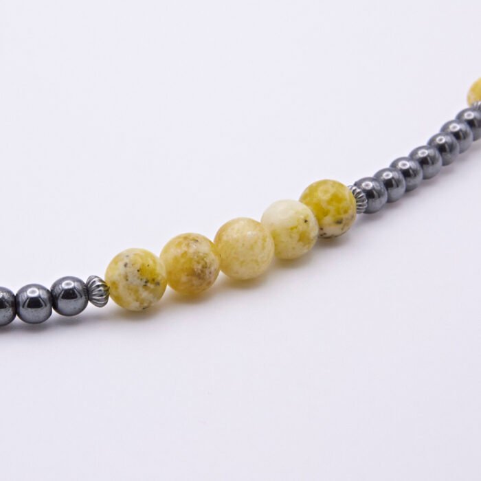 Yellow Turquoise and Hematite Necklace close up of beaded sections on flat white surface