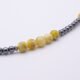 Yellow Turquoise and Hematite Necklace close up of beaded sections on flat white surface