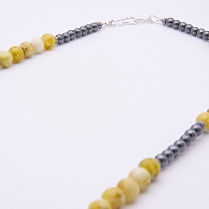 Yellow Turquoise and Hematite Necklace longer close up view of beads and clasp on flat white surface
