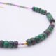 Ruby, Green Apatite and Ruby Zoisite Necklace close up of Ruby Zoisite sections of necklace on flat surface
