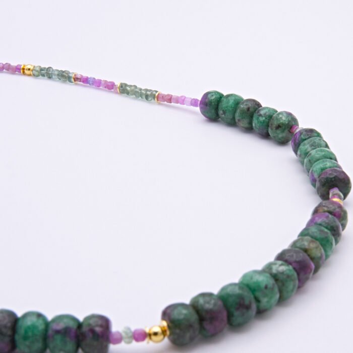 Ruby, Green Apatite and Ruby Zoisite Necklace close up showing most of Ruby Zoisite sections and some Ruby and Green Apatite on flat surface