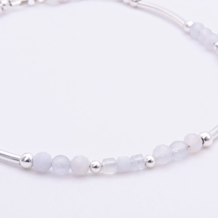Blue Lace Agate and Sterling Silver Bracelet close up of beads on plain white surface