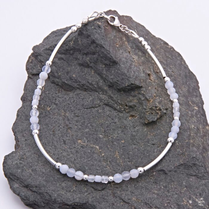 Blue Lace Agate and Sterling Silver Bracelet shown laid flat on dark grey stone