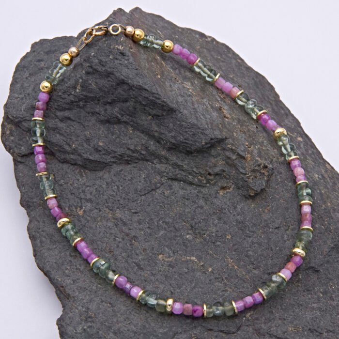 Ruby and Green Apatite Bracelet shown laid flat on dark grey stone