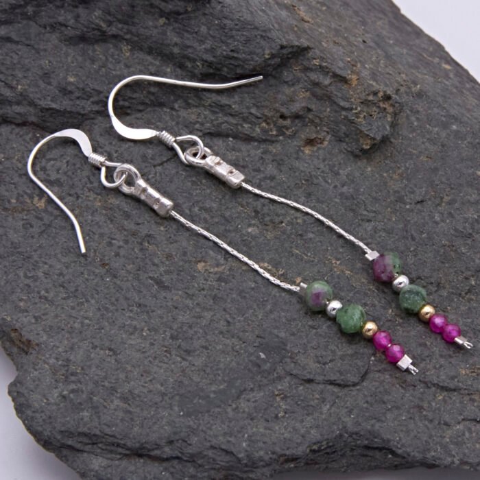 Ruby and Ruby Zoisite Sterling Silver Dangle Earrings shown laid flat on a grey stone