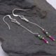 Ruby and Ruby Zoisite Sterling Silver Dangle Earrings shown laid flat on a grey stone
