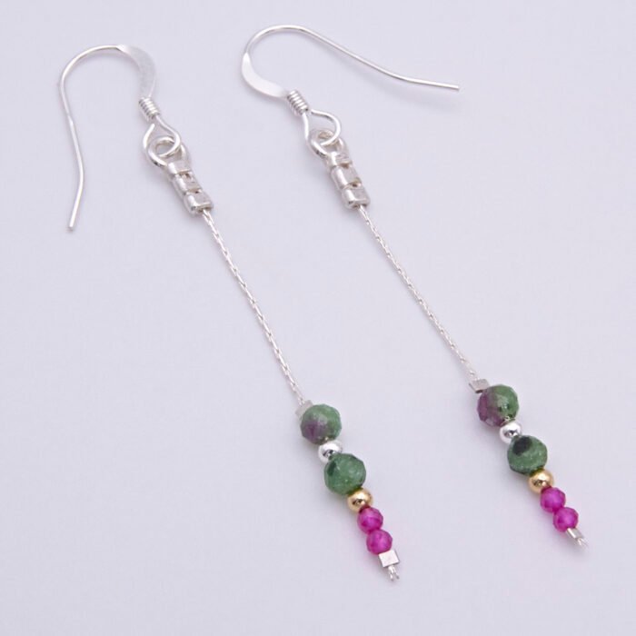 Ruby and Ruby Zoisite Sterling Silver Dangle Earrings laid flat on a white surface