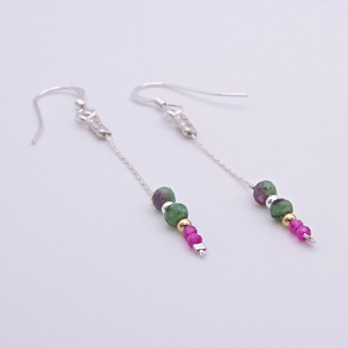Ruby and Ruby Zoisite Sterling Silver Dangle Earrings laid flat on white surface with focus on the stones