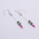 Ruby and Ruby Zoisite Sterling Silver Dangle Earrings laid flat on white surface with focus on the stones