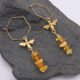 Bee and Amber Chip Dangles on Hexagon Shaped Ear Wires, shown laid flat on dark grey stone