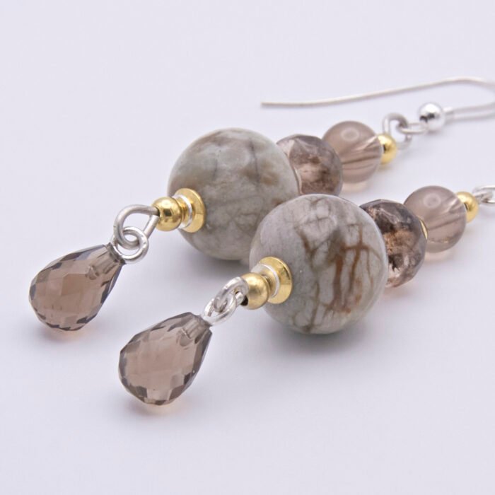 Picasso Jasper, Smoky Quartz and Smoky Watermelon Quartz mixed metals dangle earrings Picasso Jasper, Smoky Quartz and Smoky Watermelon Quartz mixed metals dangle earrings close up on flat white surface