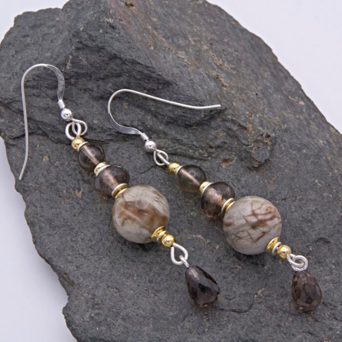 Picasso Jasper, Smoky Quartz and Smoky Watermelon Quartz mixed metals dangle earrings Picasso Jasper, Smoky Quartz and Smoky Watermelon Quartz mixed metals dangle earrings shown laid flat on dark grey stone